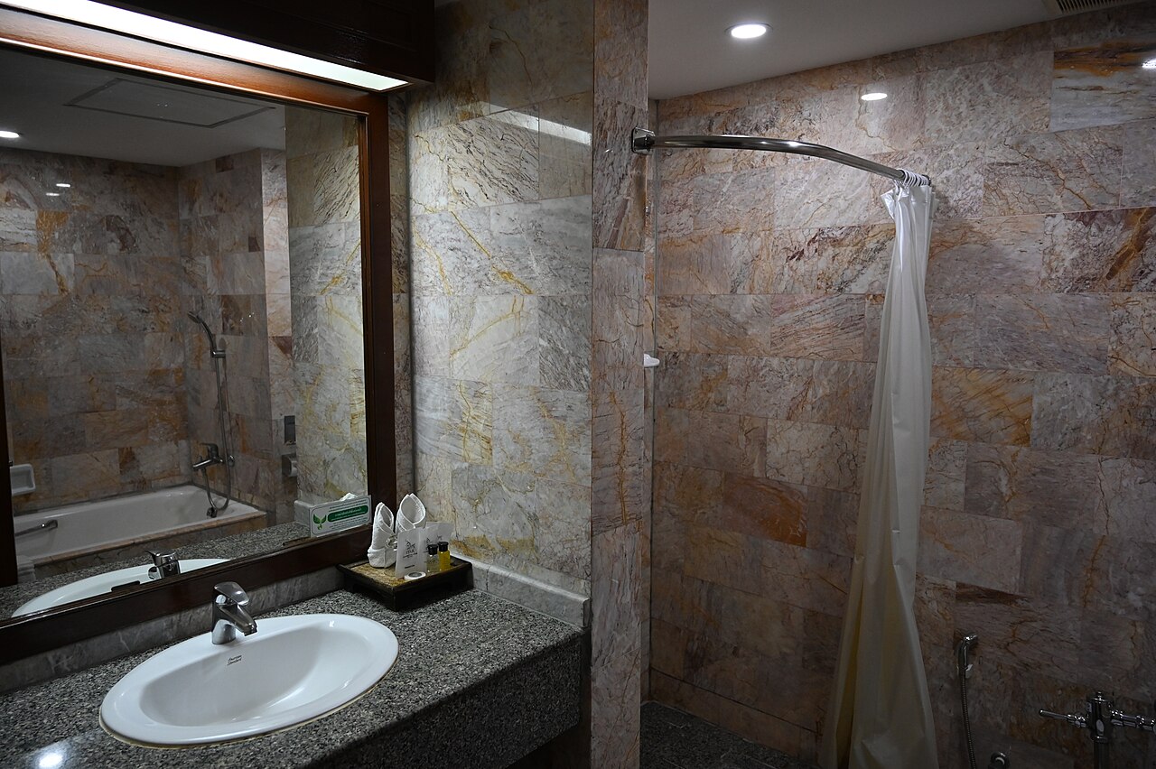Clean marble‑tiled bathroom with sink and shower